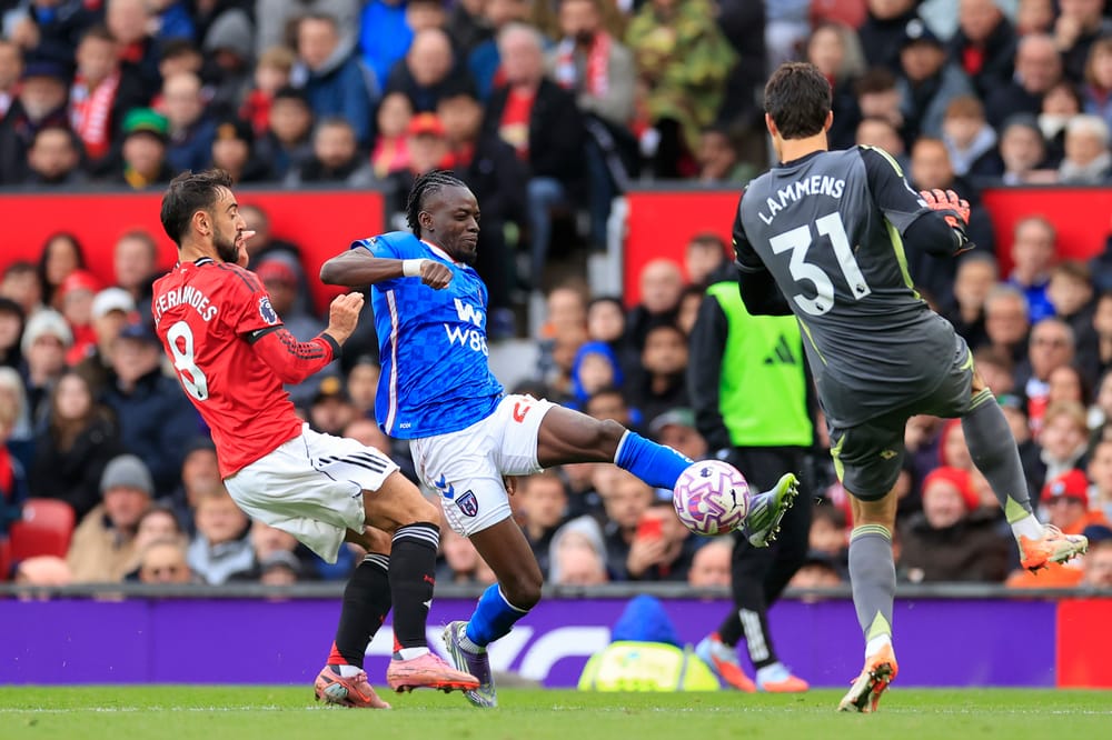 Bertrand Traore (25) of Sunderland is challenged by Senne Lammens (31) of Manchester United during the Premier League match between Manchester United and Sunderland at Old Trafford, Manchester, England on 4 October 2025.